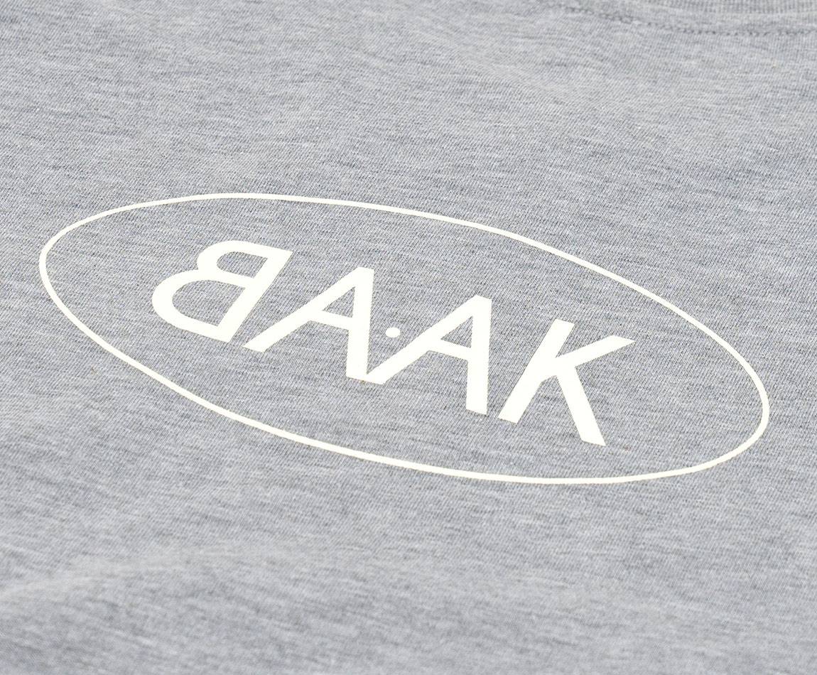 Grey T-Shirt - Short sleeves - Heart pocket on front - Screen-printed cream BAAK logo on back Grey T-Shirt - Short sleeves - Heart pocket on front - Screen-printed cream BAAK logo on back