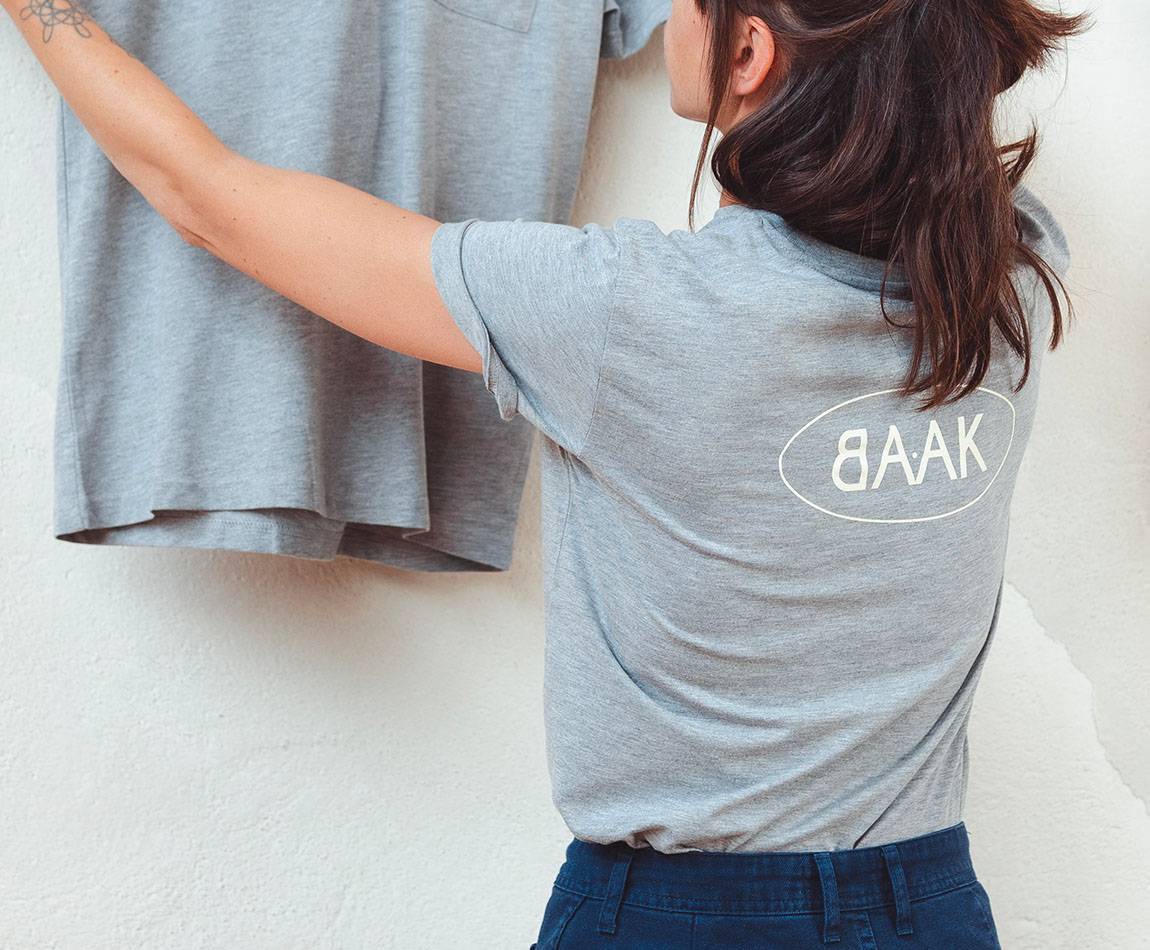 Grey T-Shirt - Short sleeves - Heart pocket on front - Screen-printed cream BAAK logo on back Grey T-Shirt - Short sleeves - Heart pocket on front - Screen-printed cream BAAK logo on back