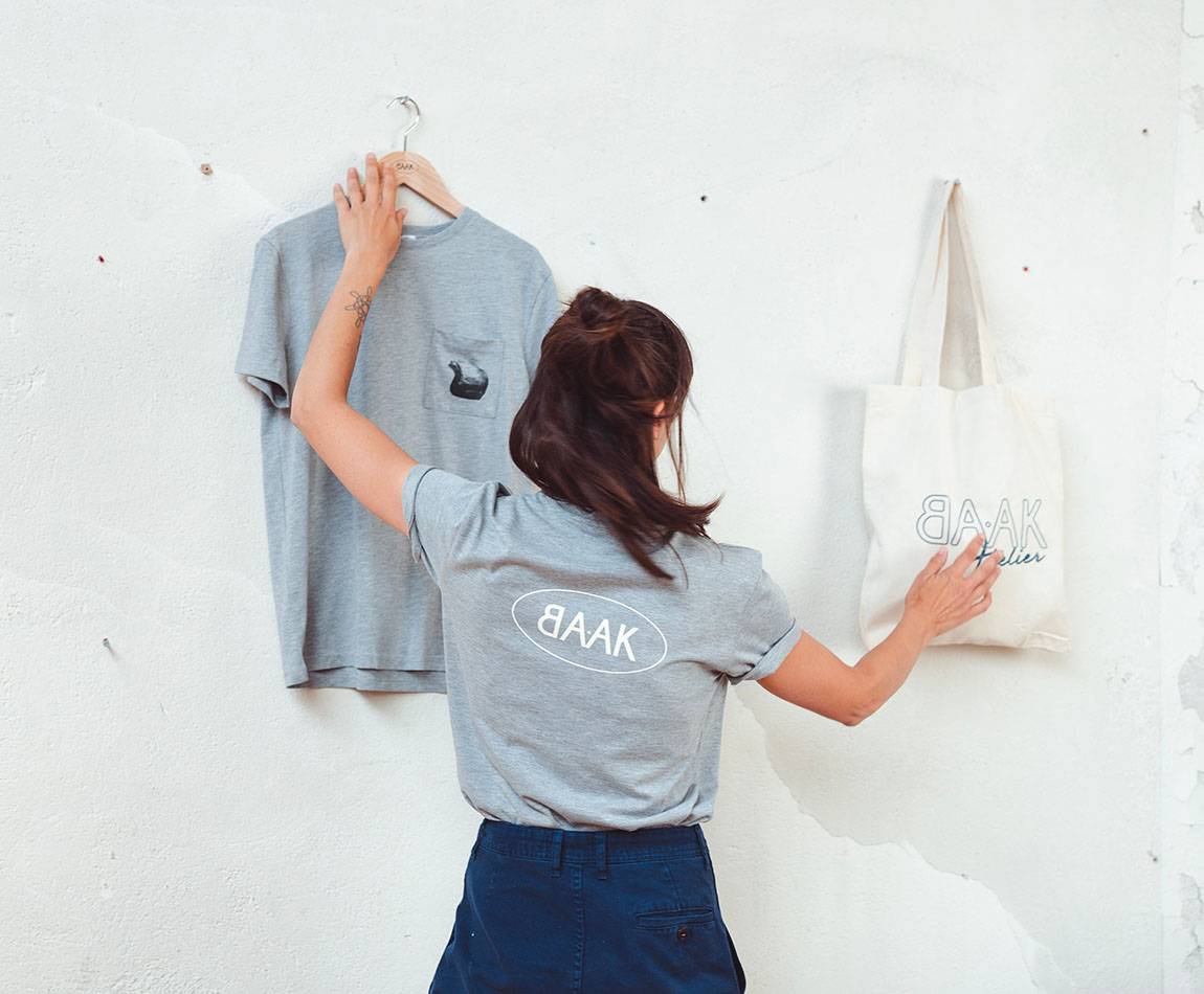 Grey T-Shirt - Short sleeves - Heart pocket on front - Screen-printed cream BAAK logo on back Grey T-Shirt - Short sleeves - Heart pocket on front - Screen-printed cream BAAK logo on back