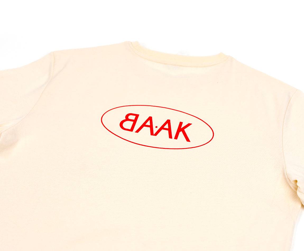 Cream T-Shirt - Short sleeves - Heart pocket on front - Screen-printed red BAAK logo on back Cream T-Shirt - Short sleeves - Heart pocket on front - Screen-printed red BAAK logo on back