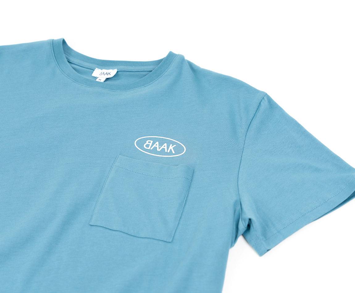 Blue T-Shirt - Short sleeves - Heart pocket on front - Screen-printed cream BAAK logo above pocket Blue T-Shirt - Short sleeves - Heart pocket on front - Screen-printed cream BAAK logo above pocket