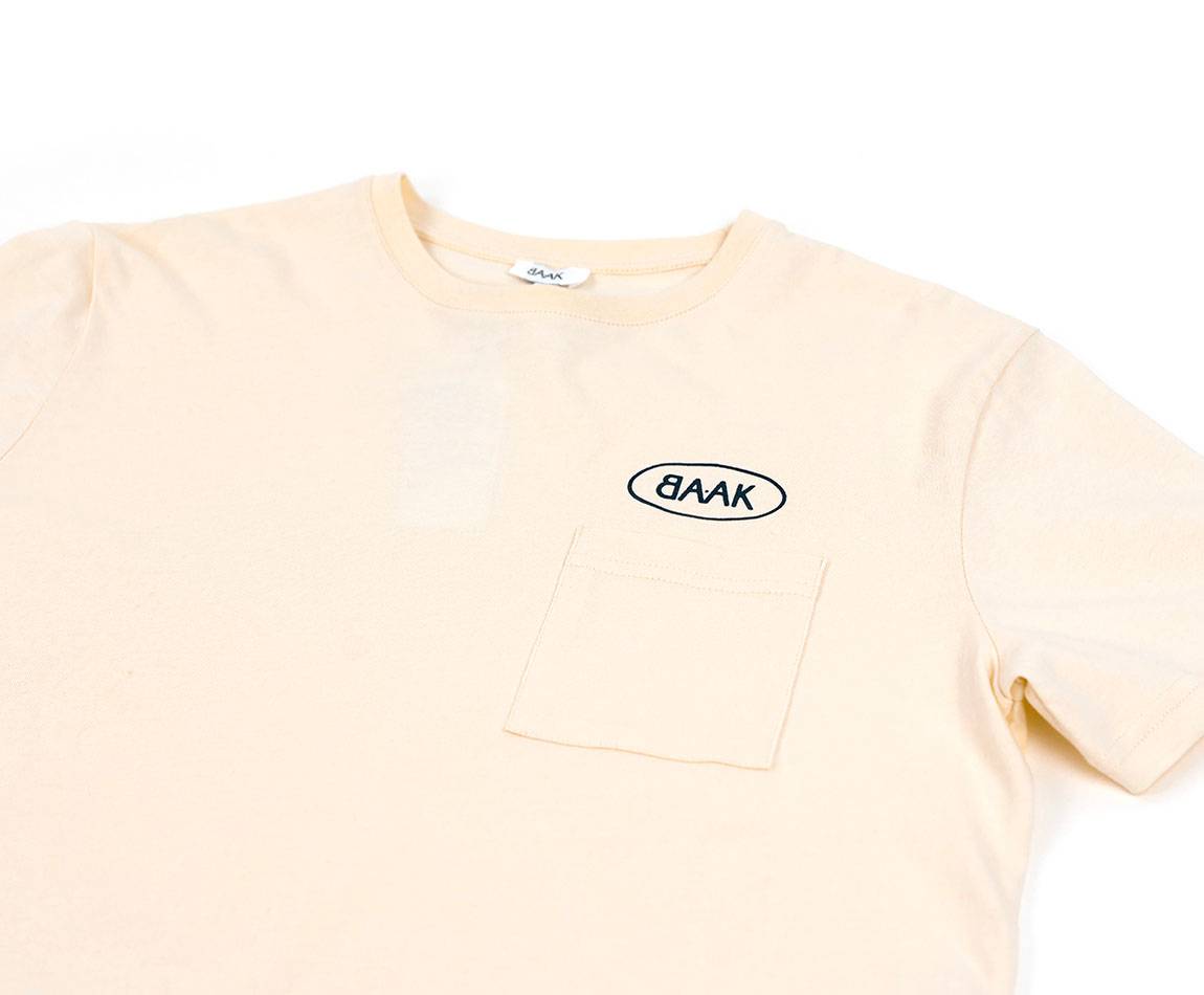 Cream T-Shirt - Short sleeves - Heart pocket on front - Petrol blue BAAK logo silk-screened above pocket Cream T-Shirt - Short sleeves - Heart pocket on front - Petrol blue BAAK logo silk-screened above pocket
