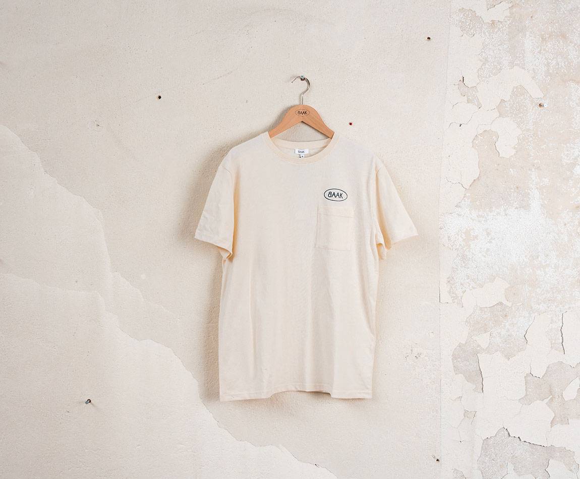 Cream T-Shirt - Short sleeves - Heart pocket on front - Petrol blue BAAK logo silk-screened above pocket Cream T-Shirt - Short sleeves - Heart pocket on front - Petrol blue BAAK logo silk-screened above pocket